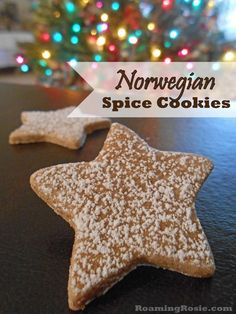 two small star shaped cookies sitting on top of a table next to a christmas tree