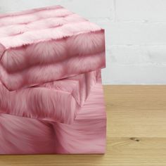 two pink boxes sitting on top of a wooden table