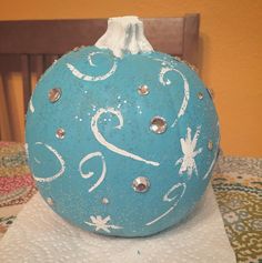 a blue painted pumpkin sitting on top of a table