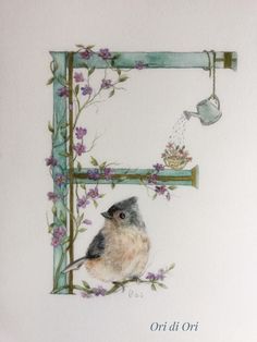 a bird sitting on top of a table next to a teapot and flowers in a frame