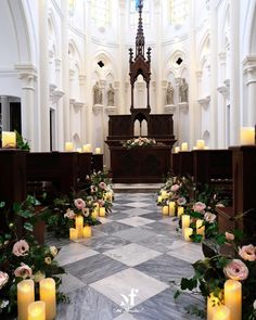 the interior of a church with candles and flowers