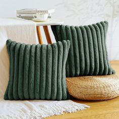 two green pillows sitting on top of a wooden floor next to a wicker basket