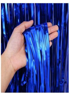 a hand is holding some shiny blue ribbons