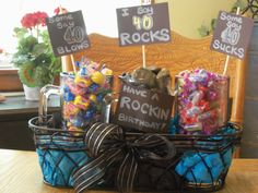 a basket filled with lots of candy sitting on top of a wooden table next to a sign