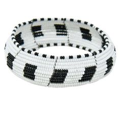 Beautiful black and white concave beaded authentic bold bangle handmade by Maasai women in Tanzania. Bangle is made out of Maasai glass beads and wire. We directly work with Maasai women to produce and market high-end beaded jewelry based on traditional beading techniques infused with modern aesthetics. Our bangles are created entirely by hand and no two are the same. Variations in size and design may occur. Each piece tells a story. Beaded jewelry is part of the Maasai identity and through our Traditional White Beaded Bracelets With Spacer Beads, White Bangle Bracelets With Spacer Beads, Traditional White Stretch Bracelet With Round Beads, White Beaded Bangle Bracelets With Large Beads, White Beaded Bangle Bracelet With Large Beads, Traditional White Bracelets With Polished Beads, Traditional White Round Beads Stretch Bracelet, Traditional White Cuff Bracelet Bangle, White Bracelets With Black Beads