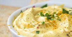 a white bowl filled with mashed potatoes on top of a table