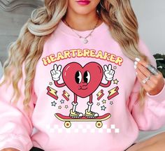 Retro Heartbreaker (2) Sweatshirt | Unisex Comfortable Pullover for Cool Weather | Unique Gifts for Family Friends   Indulge in the spirit of love and fashion with our exclusive Happy Valentine's Day crewnecks! Curated with passion and crafted for comfort, these crewnecks blend heartfelt designs with premium quality, ensuring you celebrate in style. Embrace the essence of romance and joy with each piece, perfect for cozy gatherings or expressing your affection in a chic, casual style.    Key Features: High-Quality Material: Made from soft and durable fabric, this sweatshirt is built to last and keep you warm throughout the season. Unisex Design: This versatile pullover suits all genders, offering a relaxed and comfortable fit. Charming Appeal: Our cute fall sweatshirt is designed to add a Oversized Heart Print Casual Tops, Oversized Long Sleeve Top With Heart Graphic, Casual Oversized Heart Print Tops, Long Sleeve T-shirt With Heart Graphic For Streetwear, Fall Streetwear Top With Heart Graphic, Cute Sweatshirt With Heart Graphic And Crew Neck, Heart Graphic Crew Neck Sweatshirt For Streetwear, Cute Crew Neck Sweatshirt With Heart Graphic, Casual Sweatshirt With Heart-shaped Graphic Print