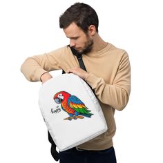 a man holding a white backpack with a colorful parrot on it's back pocket