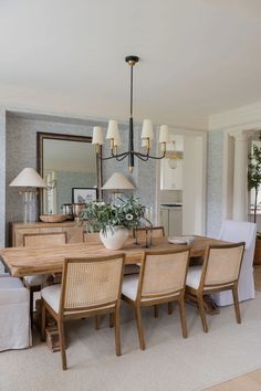 the dining room table is surrounded by wicker chairs and white linen upholstered cushions