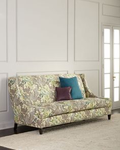 a living room with a couch and rug on the floor in front of white paneled walls