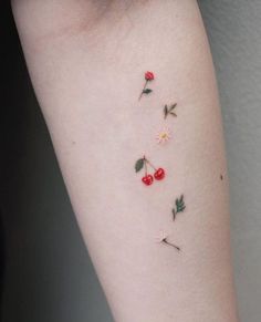 small cherry and flower tattoos on the arm