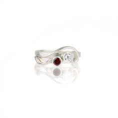 The so-called "whiplash line" is one of the defining hallmarks of the Art Nouveau style. Here, the whiplash curves in a graceful arabesque around a sparkling gemstone and entwines around your finger. The Arabesque Ring is dainty and elegant when worn alone; but this slender stacking ring is designed to nestle closely with one or more accompanying bands. This sparkly white sapphire and sterling silver ring is handcrafted and made to order. Wear it by itself, or customize a stack of skinny bands a Elegant Birthstone Ring With Tension Setting, Elegant Adjustable Gemstone Rings, Elegant Swirl Shaped Wedding Jewelry, Elegant Adjustable Birthstone Ring, Modern Twist Spiral Jewelry For Anniversary, Elegant Sterling Silver Bypass Wedding Ring, Elegant Sterling Silver Bypass Ring For Wedding, Elegant Spiral Bypass Ring, Elegant Adjustable Diamond Birthstone Ring