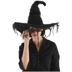 a woman wearing a black witches hat and holding her hands up to her face with one hand