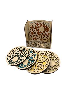 four wooden coasters with laser cut designs on the front and back, in an open box