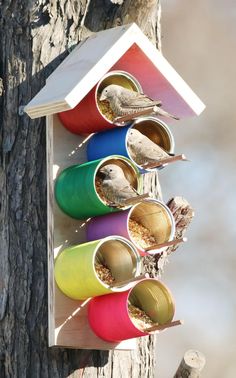 a bird house that is hanging from a tree with several birds in it's holes