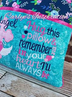 a blue bag with pink and white designs on it sitting on top of a wooden bench