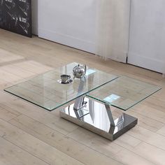 a glass coffee table sitting on top of a hard wood floor