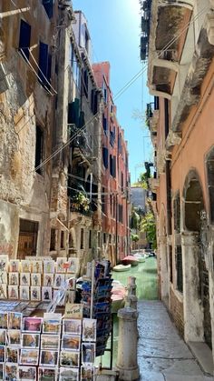 an alley way with books and magazines on the shelves next to buildings in venice, italy