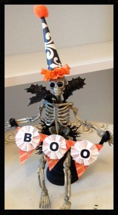 a skeleton wearing a party hat and holding a boo sign