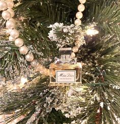 a bottle of perfume sitting on top of a christmas tree