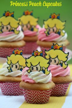 princess peach cupcakes with pink frosting and bows on top are sitting on a table