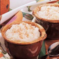 two brown cups filled with oatmeal sitting on top of a table