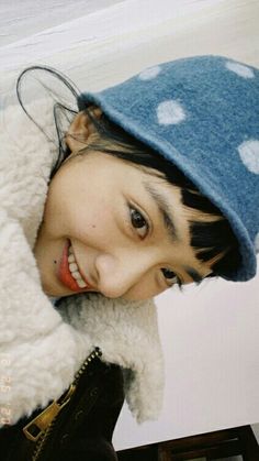 a young woman wearing a blue and white polka dot hat