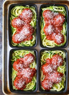 four plastic trays filled with different types of spaghetti and meat covered in marinara sauce