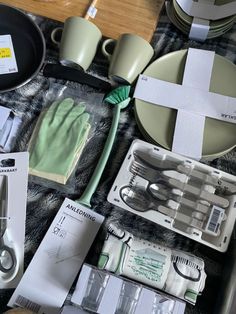 the table is full of kitchen items including scissors, gloves and other household care products