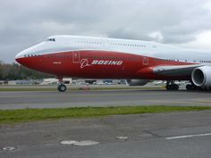 a red and white plane is on the runway