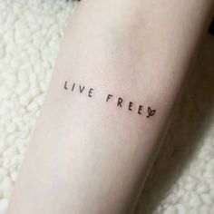 a woman's arm with the words live free tattooed on her left leg, in black ink