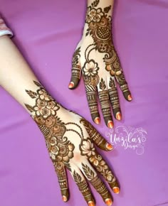 two hands with henna tattoos on them