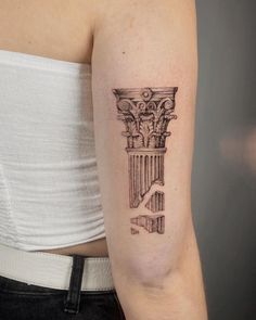 a woman's arm with a tattoo on it that has an image of a roman column