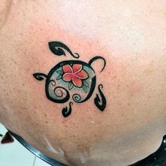 a woman's stomach with a tattoo design on the back of her belly and an orange flower in the center