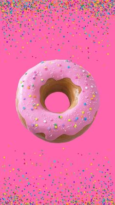 a donut with pink frosting and sprinkles on a pink background