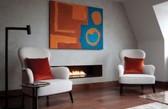 a living room with two white chairs and a fire place in the middle of it