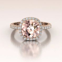 an engagement ring with a pink diamond surrounded by diamonds