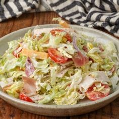 a white bowl filled with salad on top of a wooden table