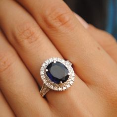 a woman's hand with a diamond and sapphire ring