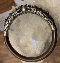 This fantastic bracelet features a pair of silver dragons joined by a silver sphere. The circle is completed with lightweight, medium tone bamboo. The detail on this amazing piece is exquisitely gorgeous, and this bangle is in excellent condition. The inner diameter is 2.5 inches, and the bracelet is approximately 0.35 inches wide from the side view. A glorious and evocative piece that will make a wonderful wedding gift or heirloom! Traditional Dragon Design Collectible Jewelry, Unique Bangle With Polished Finish, Unique Round Bangle With Polished Finish, Silver Dragon Design Jewelry For Formal Occasions, Traditional Round Jewelry With Dragon Design, Silver Jewelry With Dragon Design For Formal Occasions, Antique Silver Round Bracelet For Wedding, Formal Silver Jewelry With Dragon Design, Antique Silver Round Bracelets For Wedding