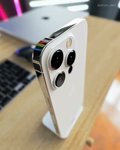 an iphone is sitting on a desk next to a laptop