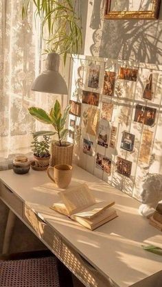 a desk with a book, potted plant and pictures on the wall