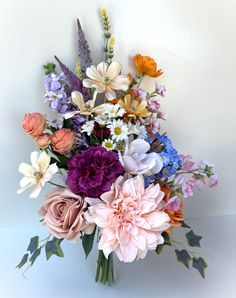 a vase filled with lots of different colored flowers