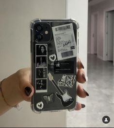 a person holding up a phone case with some stickers on it