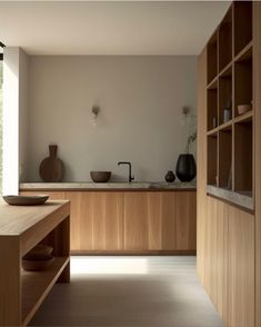 a large kitchen with wooden cabinets and counter tops, along with bowls on the counters