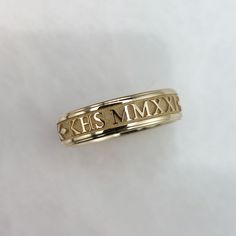 This is a class ring in solid 10K gold. Your year in Roman Numerals( can be in standard digits if you prefer) and school letters are cast right into the ring. Choose the year and up to five school letters to appear on the ring. Features of the ring:    -Font is Times New Roman    - Background is highly textured and sandblasted    - laurel motif frames the school letters and year    -Band is 5mm wide and 1.5mm thick.     - 1mm wide borders which include a step    -Made to order in your size.    - Roman Background, Years In Roman Numerals, High School Rings, Roman Numeral Ring, School Rings, Vine Ring, Times New Roman, Wide Ring, Wide Rings