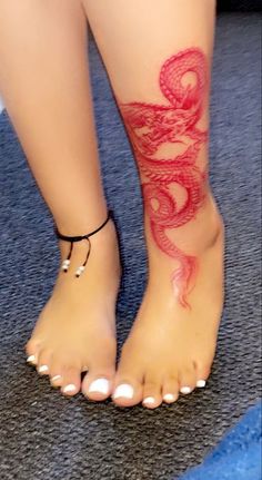 a woman's foot with a red tattoo on it