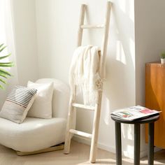 a white chair sitting next to a wooden ladder