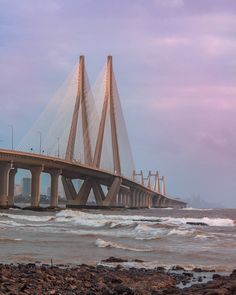 a large bridge spanning over the ocean on a cloudy day