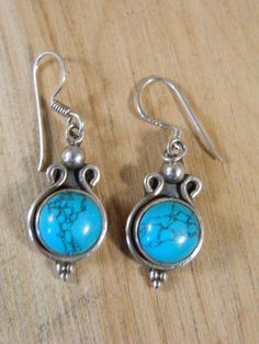 These are some beautiful vintage sterling silver and turquoise ear wire hook earrings. Each earring is made from an round-shaped piece of blue turquoise set in a lovely sterling silver frame. These earrings are simple and great for everyday wear. They are marked 925 on the hook portion of the posts.| MEASUREMENTS |Width: 3/8"Length:  1"Weight: 2g| DETAILS |Era: 1980sStyle: Ear Wire HookMaterial: Sterling silver and turquoiseColors: Silver, turquoise, blueCondition: Excellent, metal has normal pa Turquoise Sterling Silver Earrings With Lever Back, Turquoise Dangle Jewelry With French Hook, Turquoise Jewelry With French Hook For Gift, Turquoise Round Sterling Silver Earrings, Vintage Turquoise Round Earrings, Blue Vintage Sterling Silver Earrings, Earrings Native American, Native American Earrings, Earrings Vintage